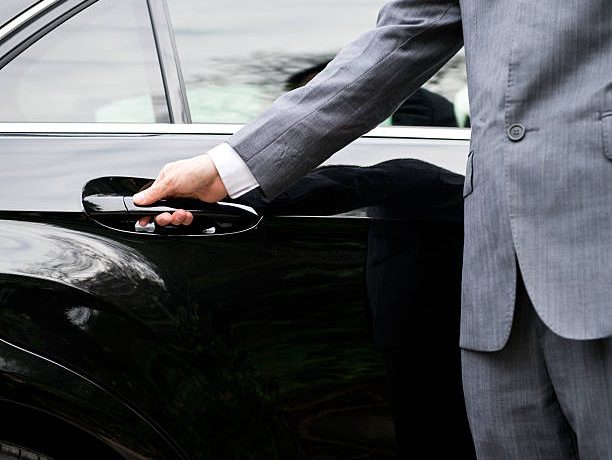 Closeup of a doormans opening a car door.